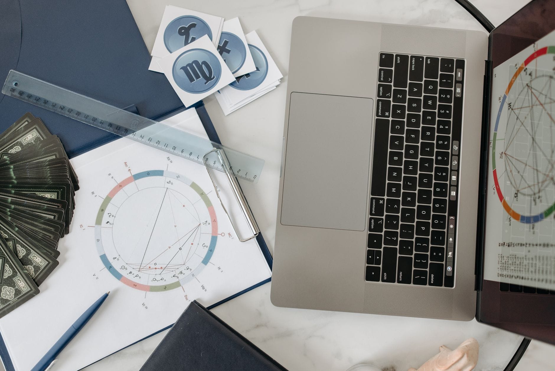 Karty tarota, laptop i wykres astrologiczny na biurku